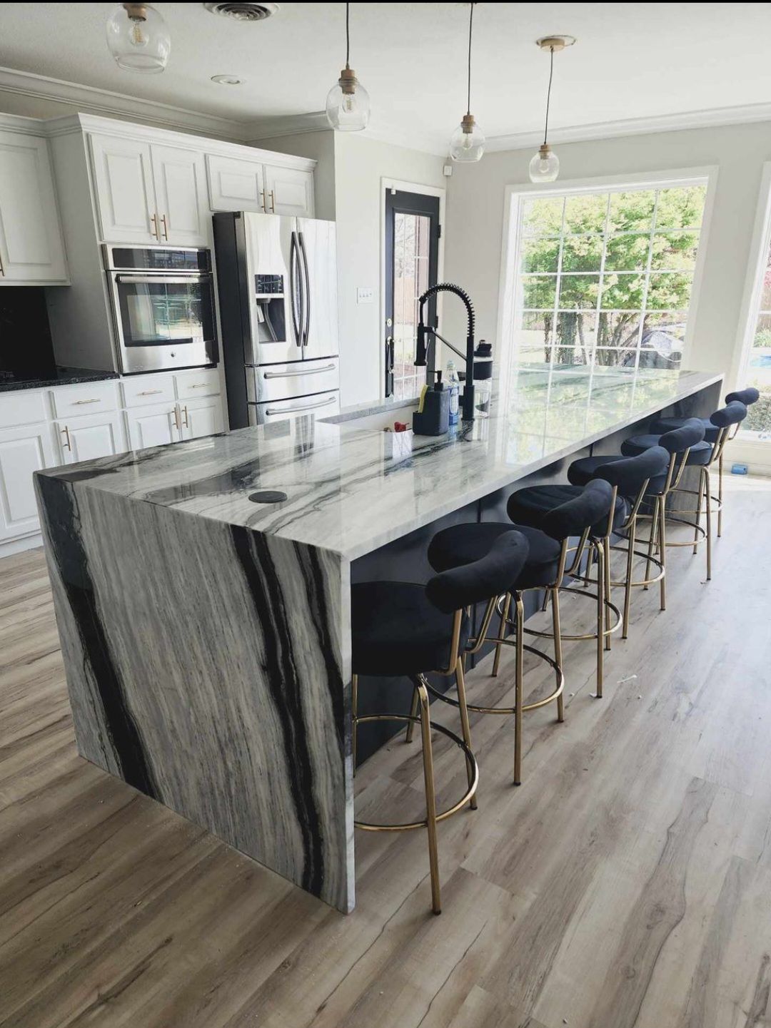 A kitchen with a large island and stools.