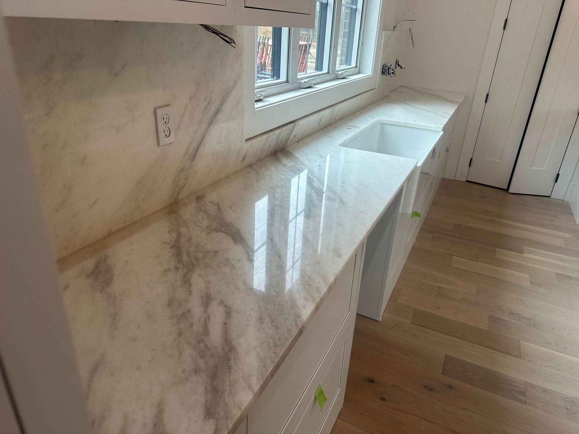 A kitchen with marble counter tops and a sink.