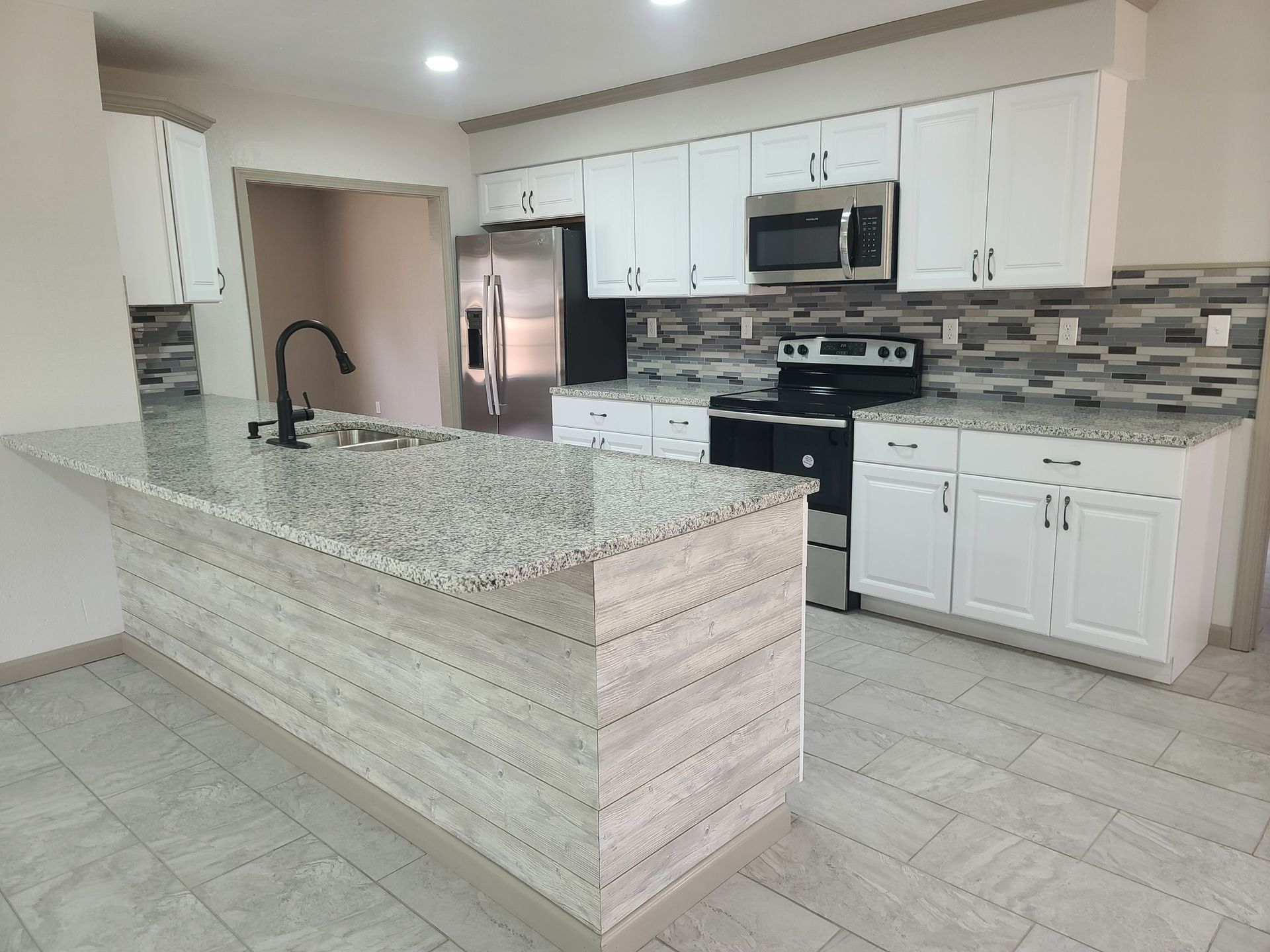 A kitchen with granite counter tops and stainless steel appliances