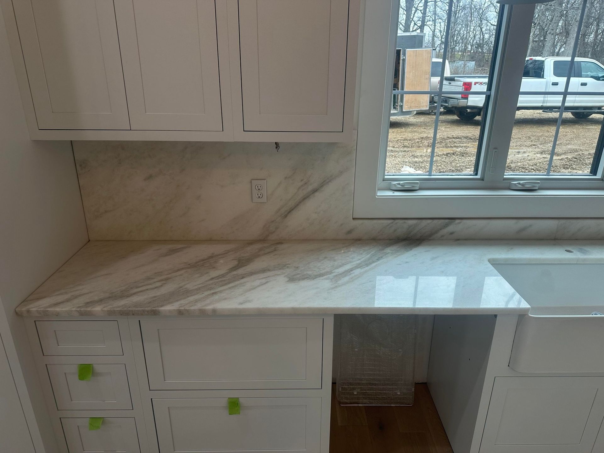 A kitchen with white cabinets , and new countertop