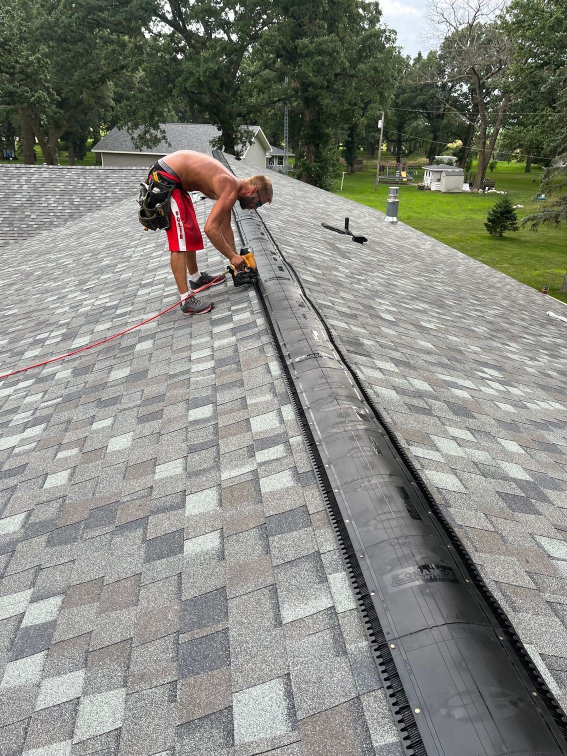 a man is working on a roof with a drill