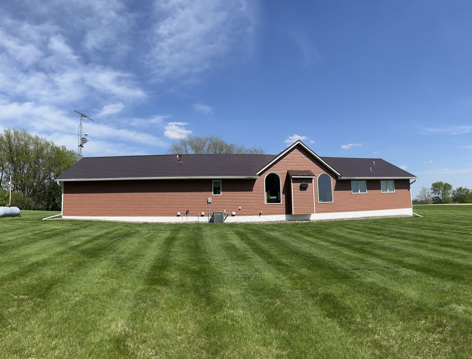 a large house is sitting in the middle of a lush green field