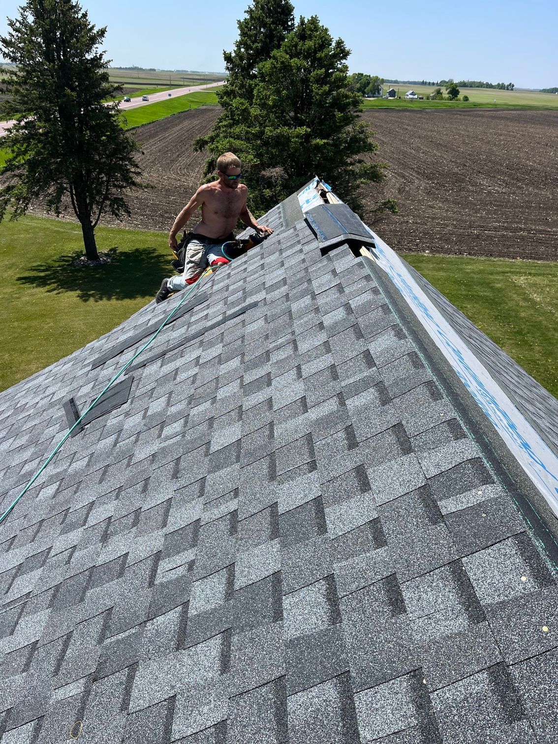 a man is sitting on the roof of a house