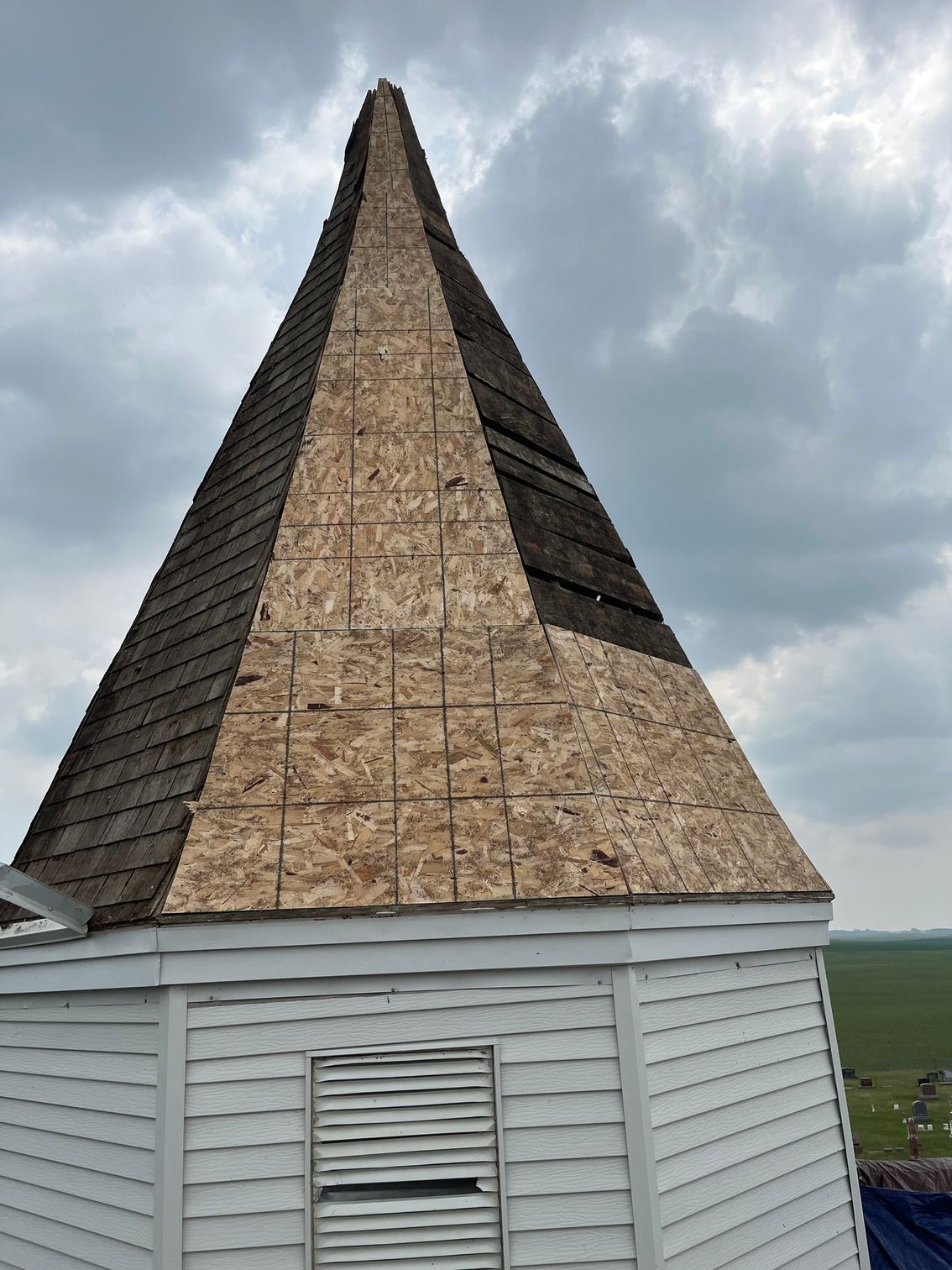 a pyramid shaped roof is being built on top of a white building