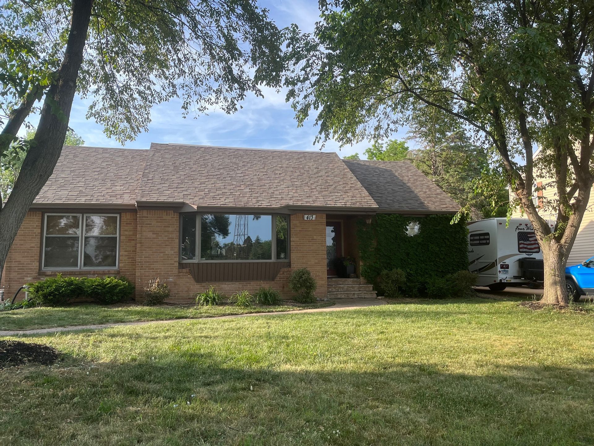 a brick house with a trailer parked in front of it
