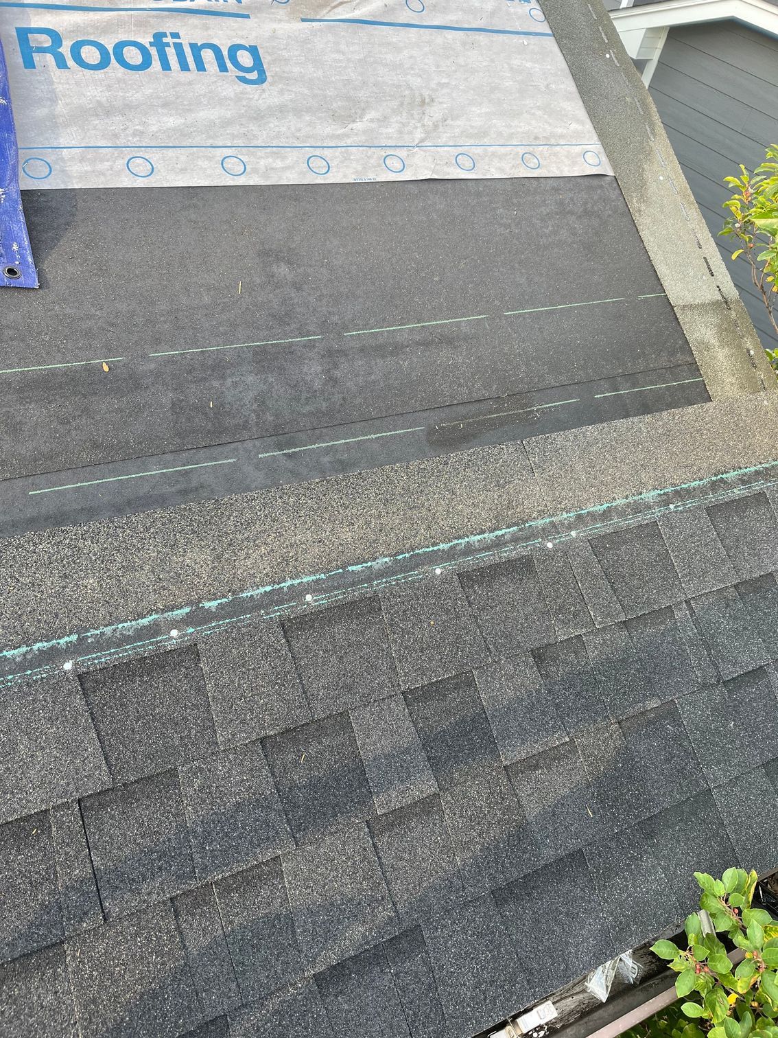 an aerial view of a roof with shingles being installed