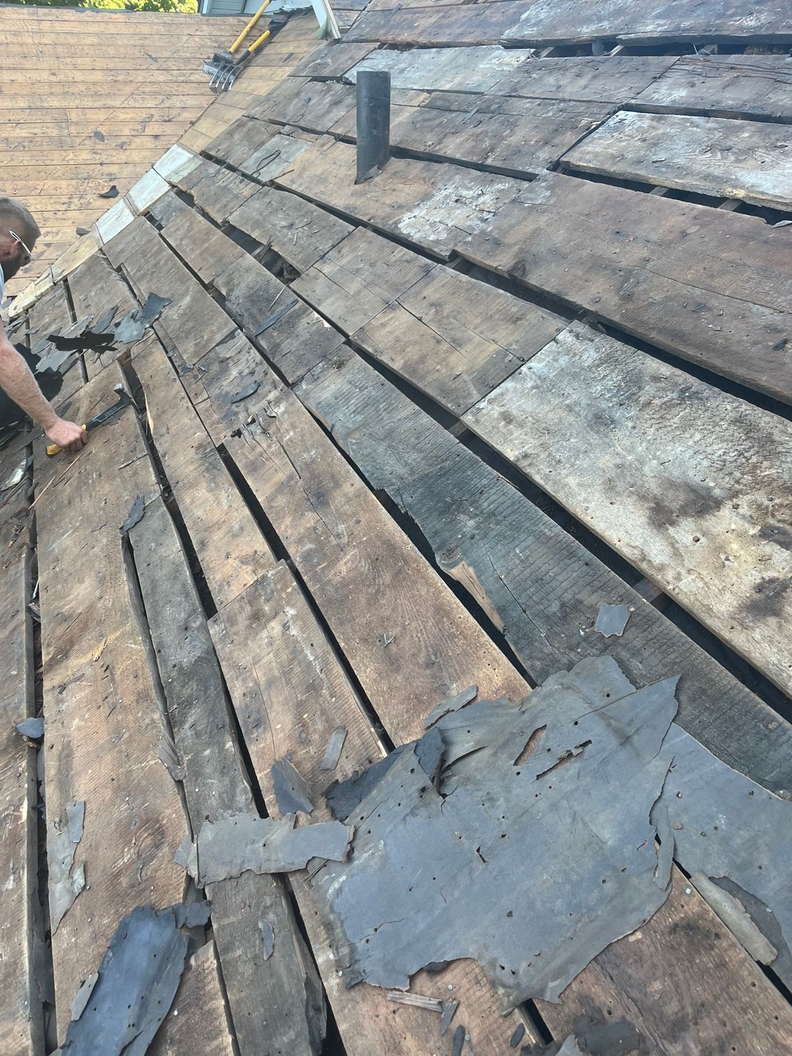 a man is working on a wooden roof with a hammer