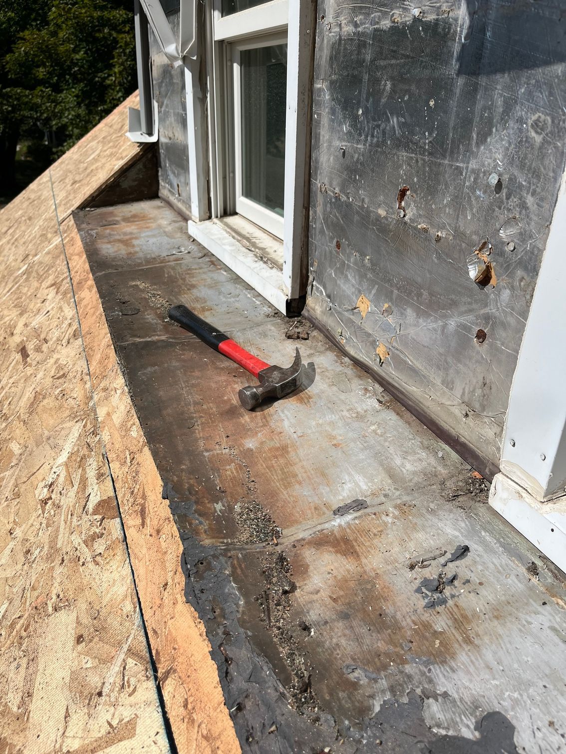 a hammer is sitting on the roof of a building next to a window