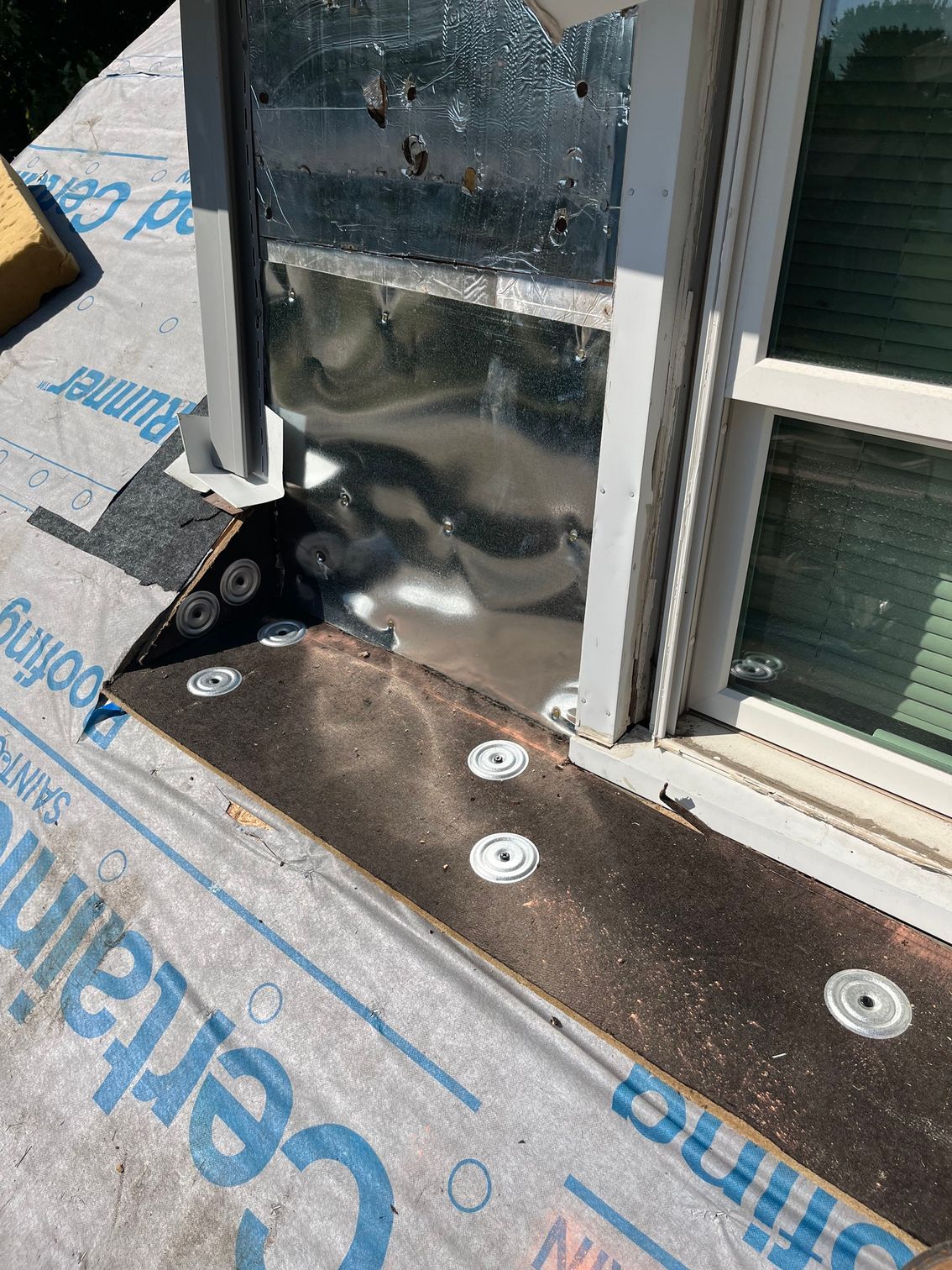a window is being installed on a roof with a certainty roofing sheet