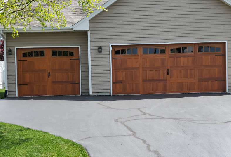 There are two garage doors on the side of a house.
