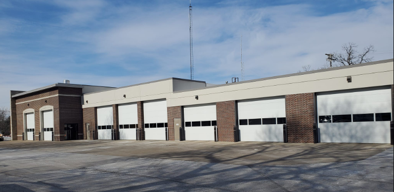A brick building with a lot of white garage doors