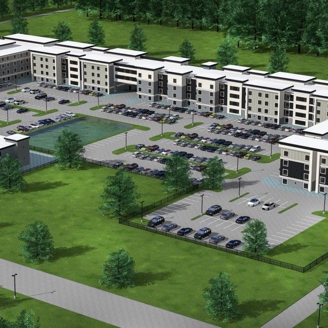 An aerial view of a large building with lots of cars parked in front of it