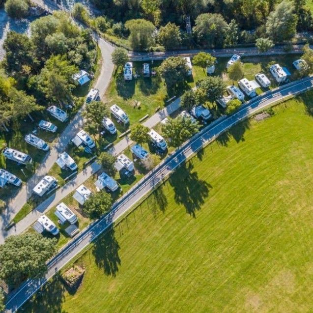 An aerial view of a row of rvs parked on the side of a road.