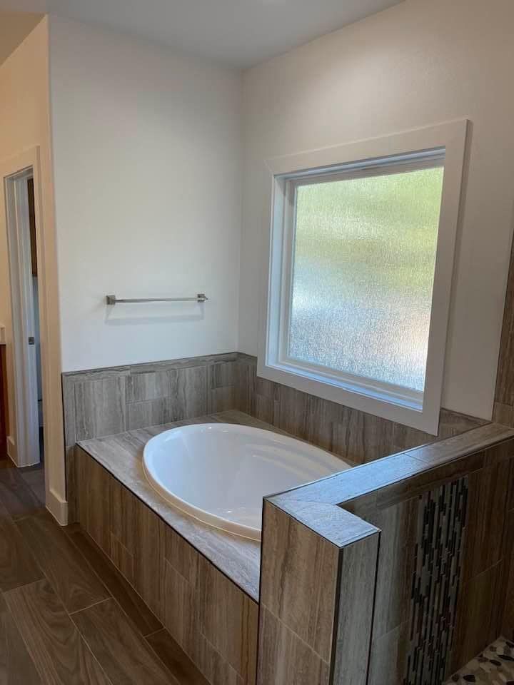 A bathroom with a jacuzzi tub and a window.