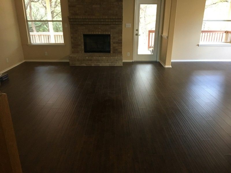 An empty living room with hardwood floors and a fireplace.