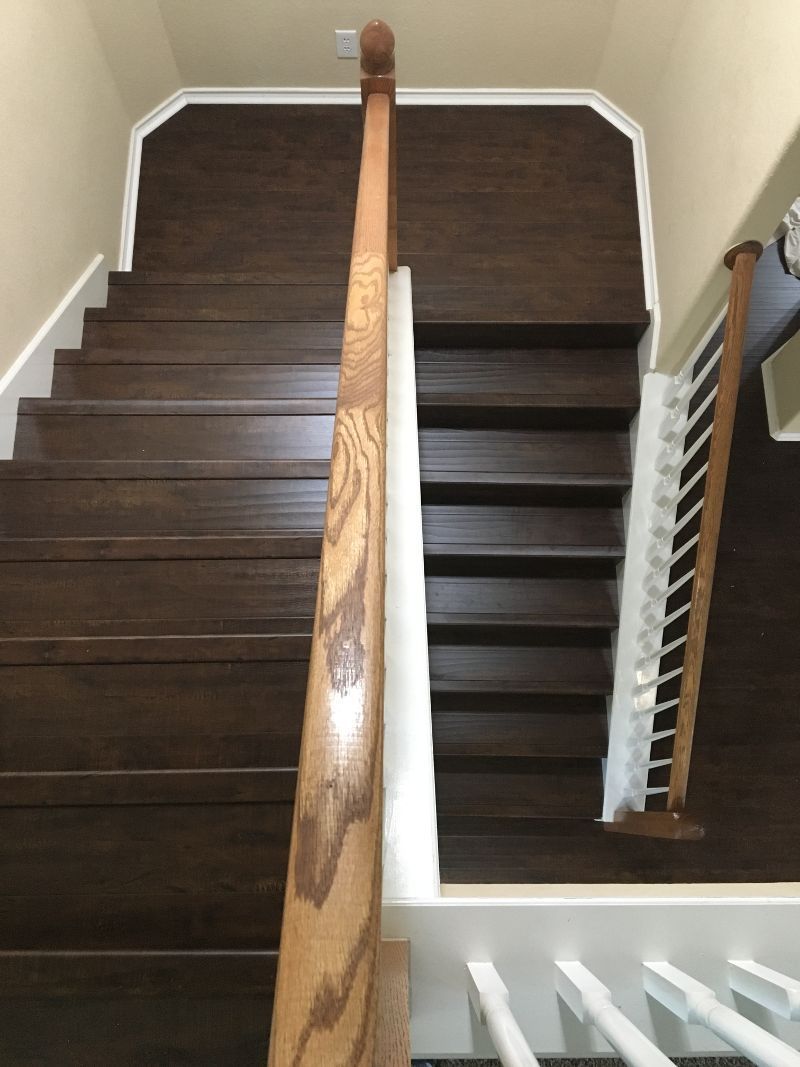 A wooden staircase with a white railing