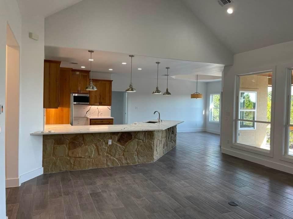 An empty kitchen with a large island in the middle of the room.