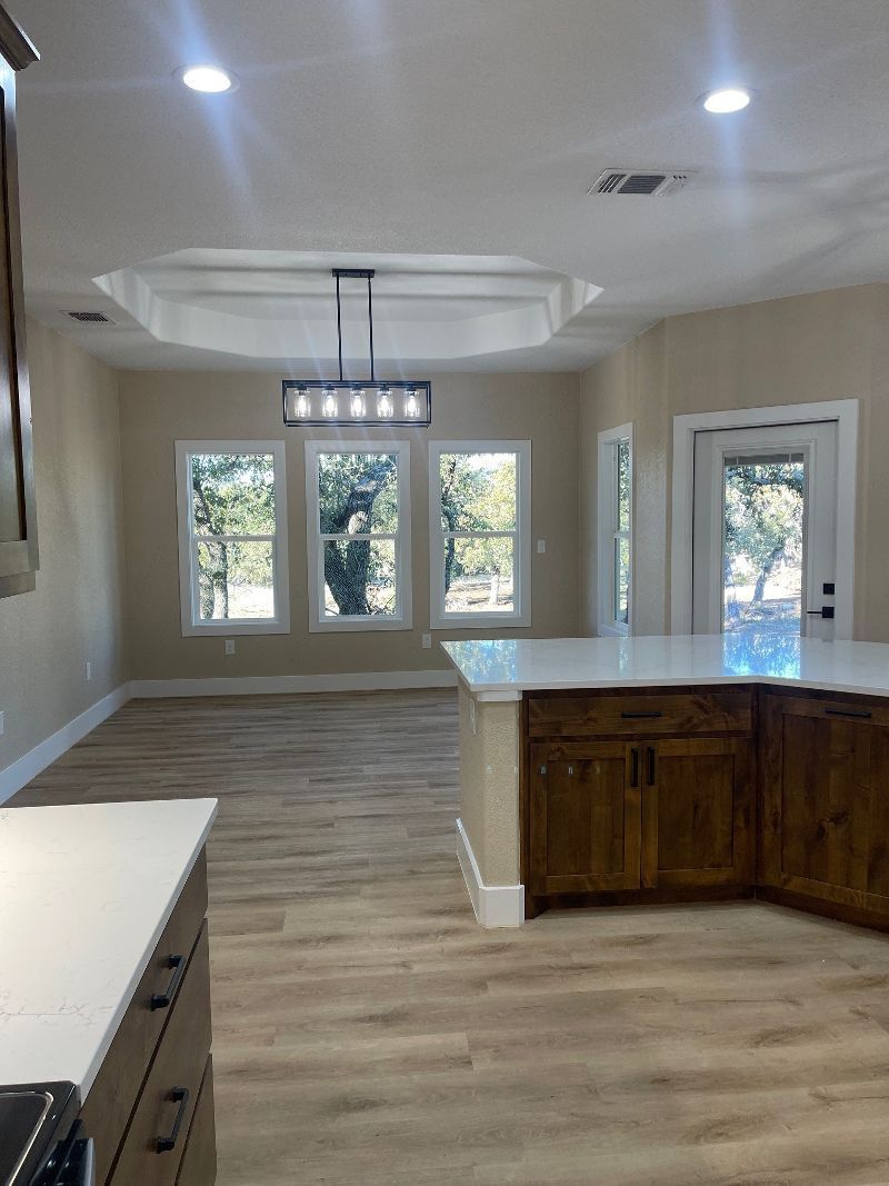 A kitchen with wooden cabinets and a large island in the middle of the room.
