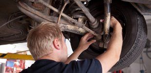 Mechanic inspecting car wheel