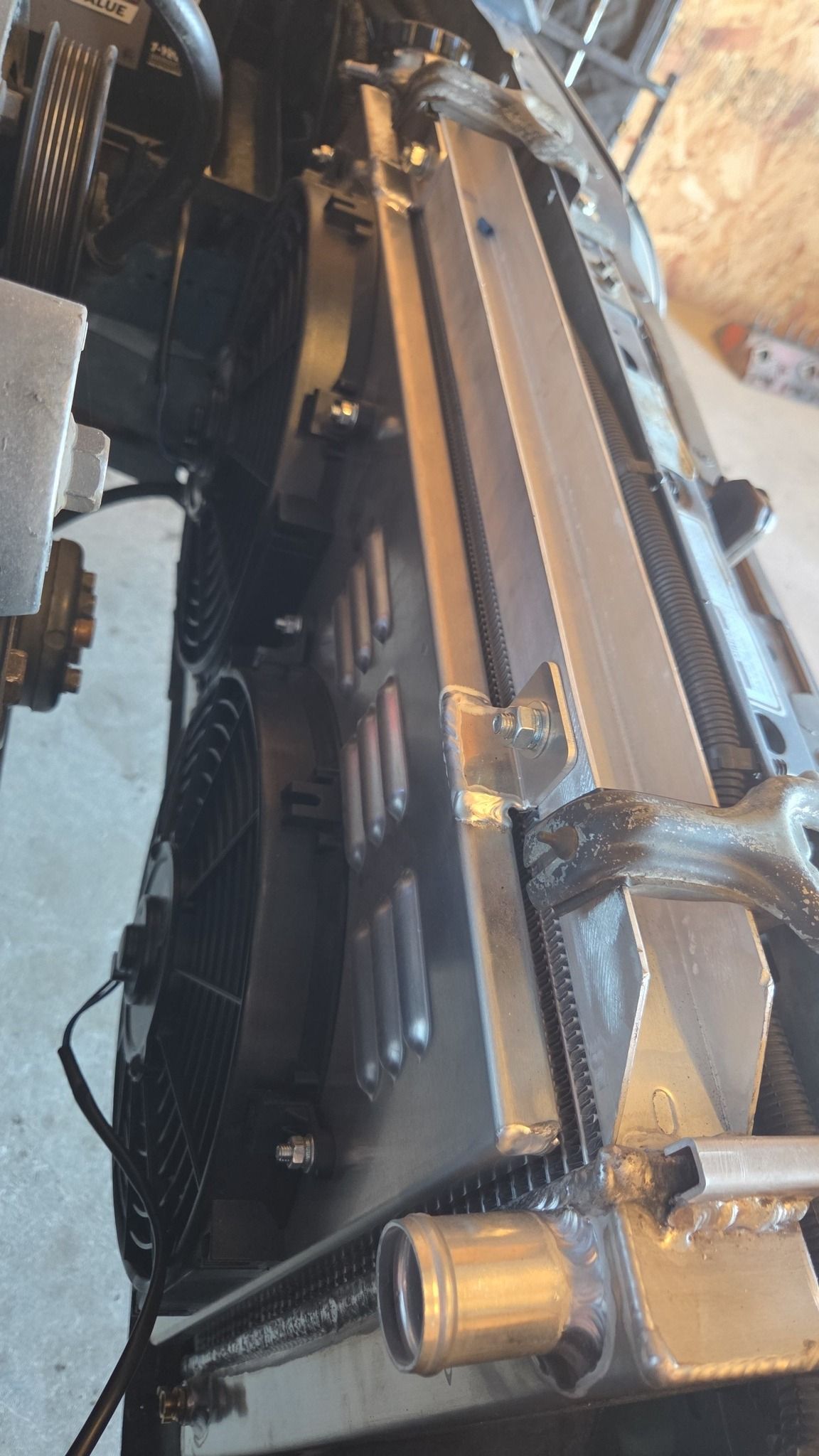 Close-up of a heavy hydraulic machine arm with black hoses and metal fittings in a workshop