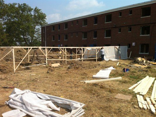 Back hoe demolitioning the house