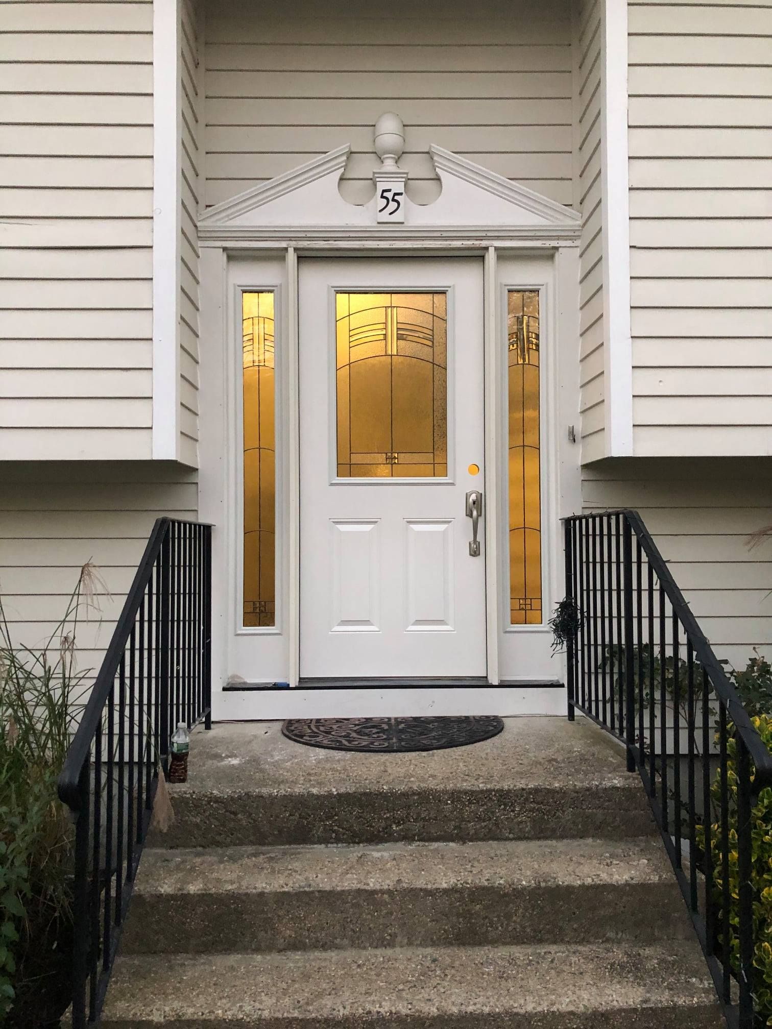 White front door with sidelights, steps leading up. Black railings. Address number 35.