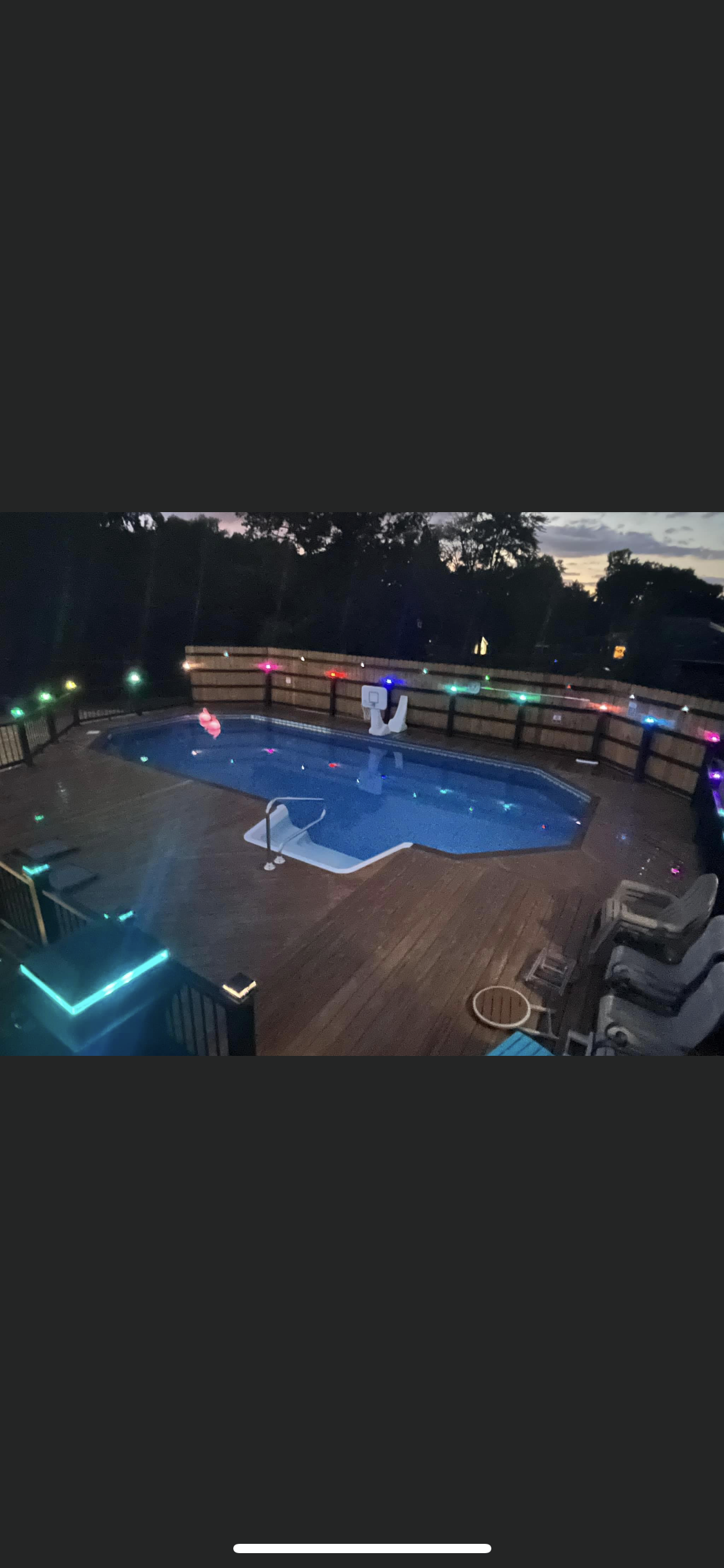 A large swimming pool is lit up at night.