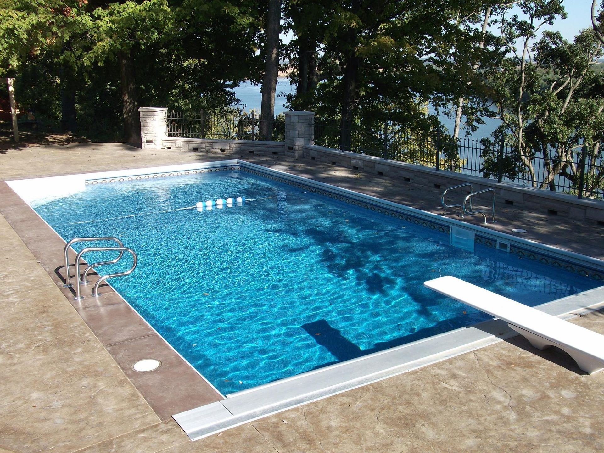 A large swimming pool with a diving board in the middle