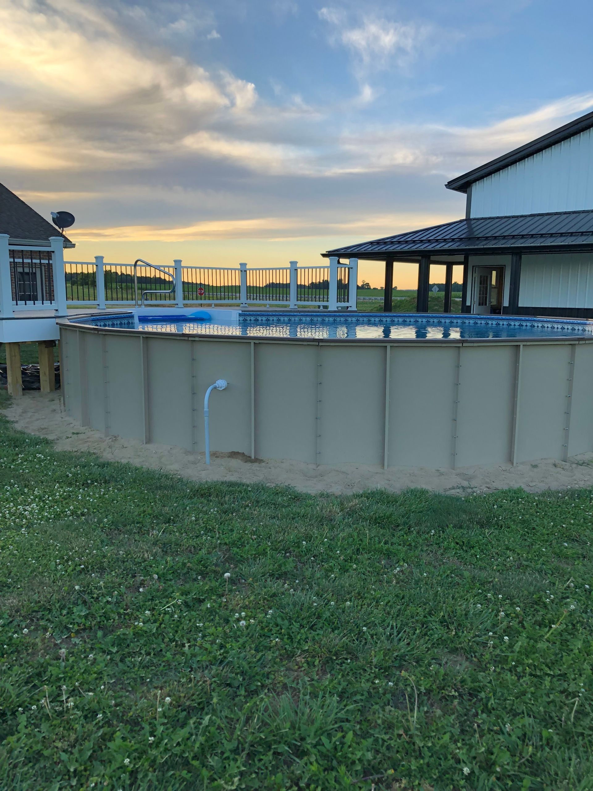 A large swimming pool with a house in the background