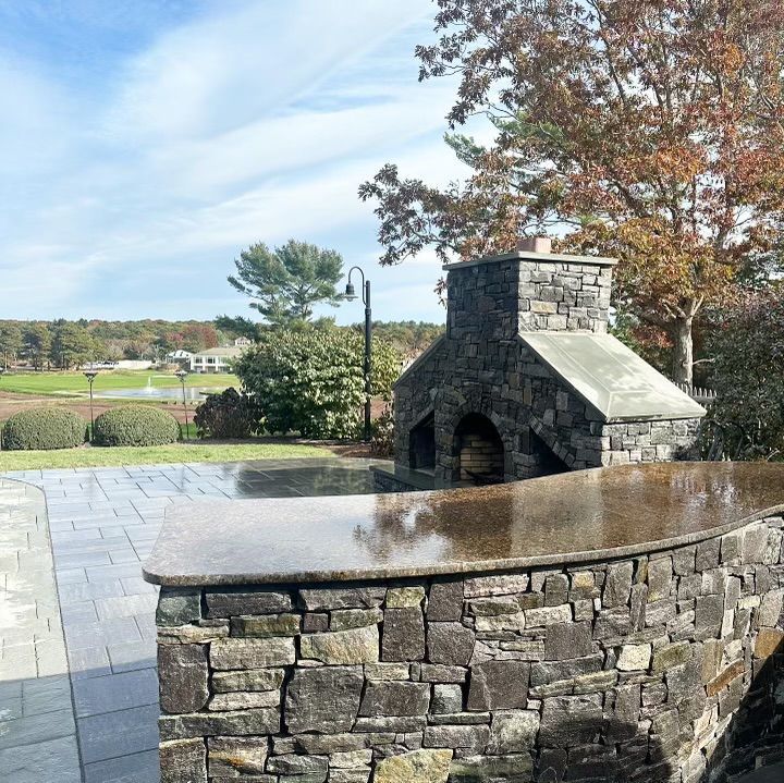A stone fireplace with a granite counter top in front of it