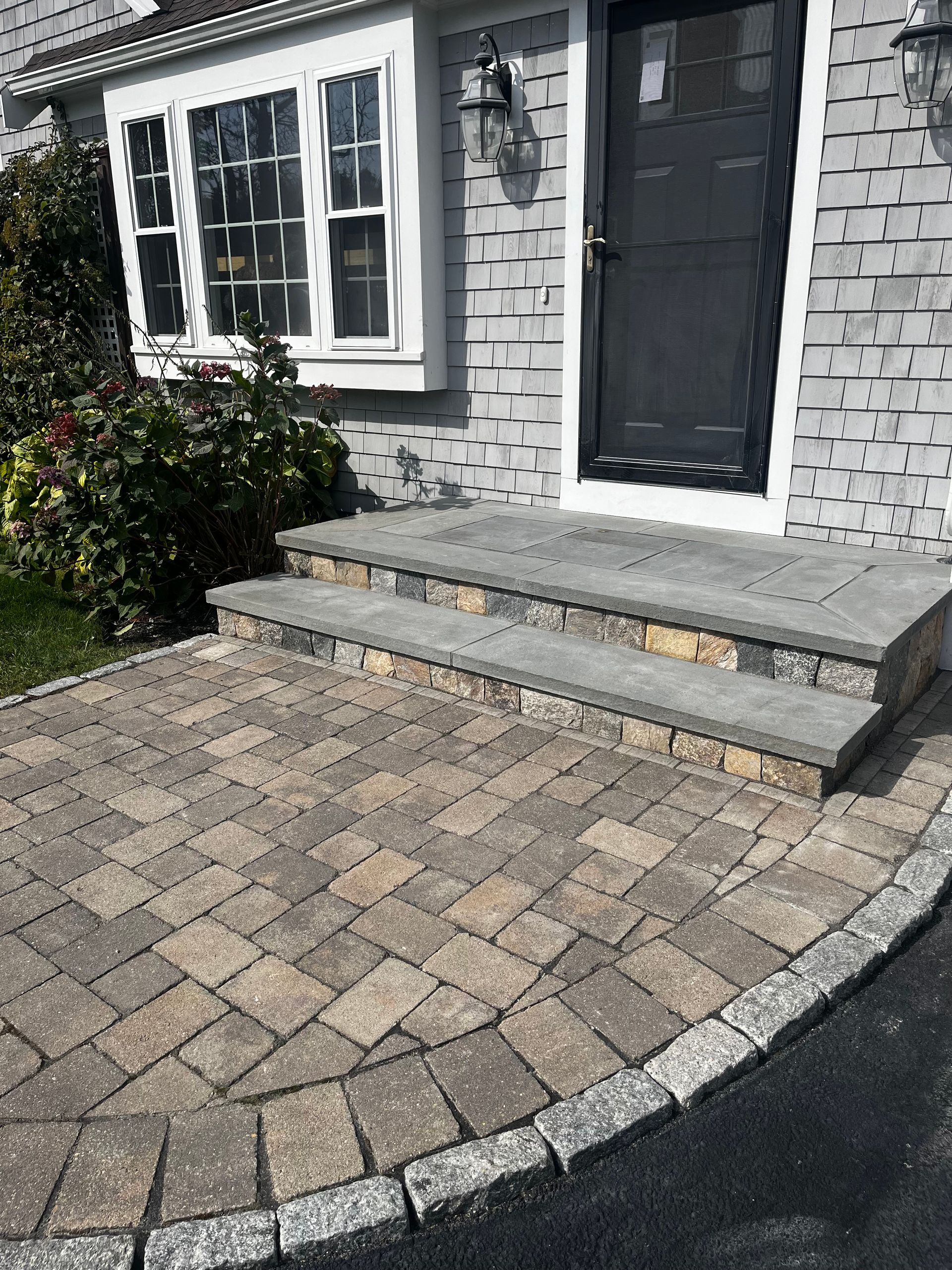 A brick walkway leading to the front door of a house.