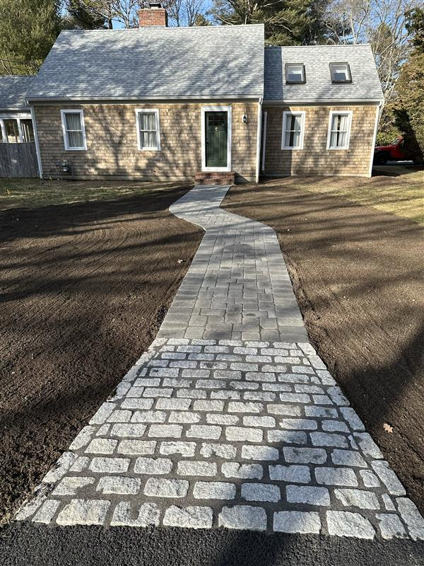 A person wearing gloves is cutting branches in a garden.