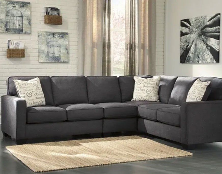 Dark gray sectionals with white pillows