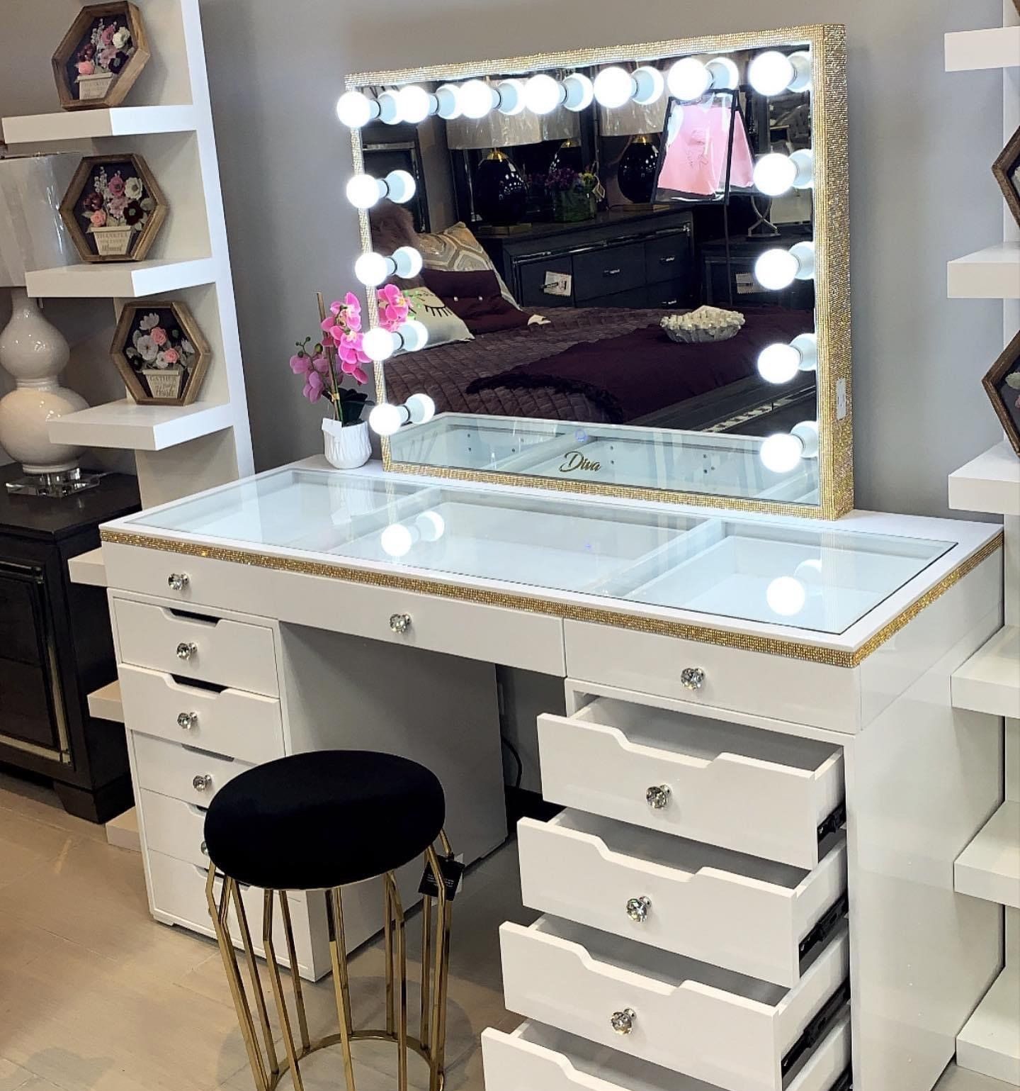 White vanity table with several drawers, lights and a black stool
