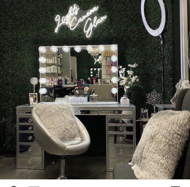 Chrome-colored vanity table with light bulbs and soft-cushioned chair