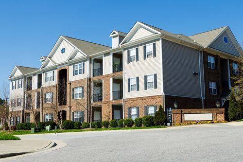 A large apartment building with a blue sky in the background