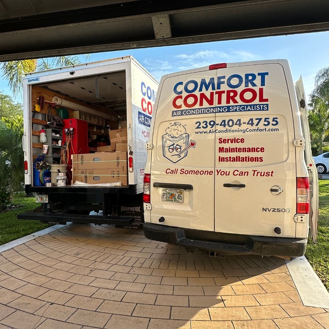 A white comfort control van is parked in a driveway.