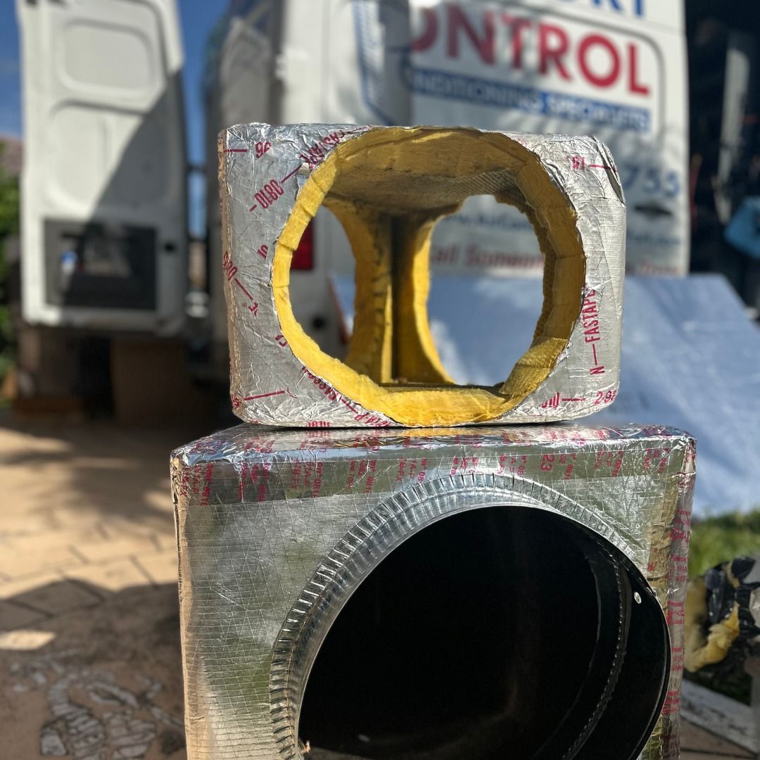 Two pieces of metal are stacked on top of each other in front of a control van.