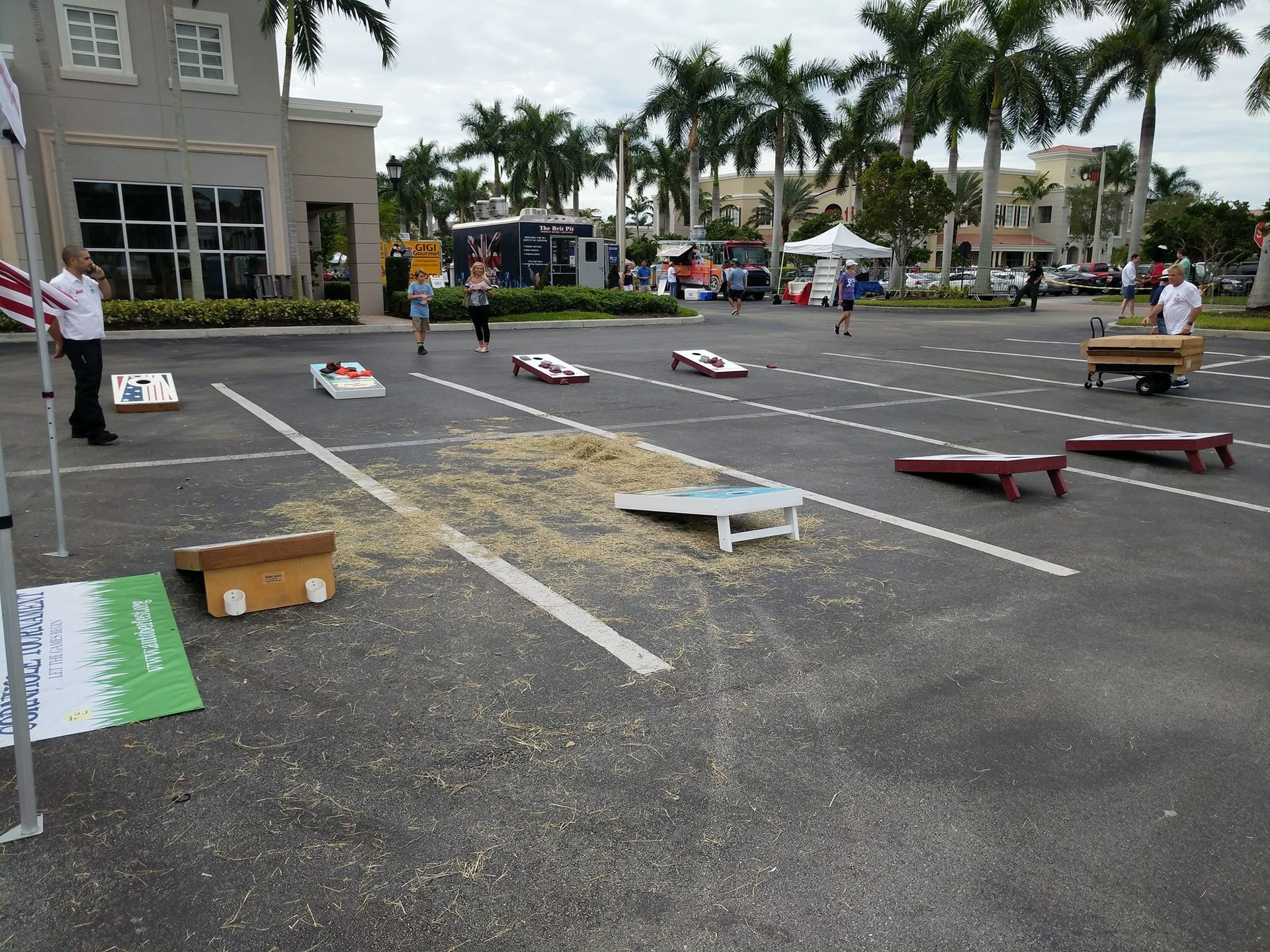 A group of people are playing cornhole in a parking lot