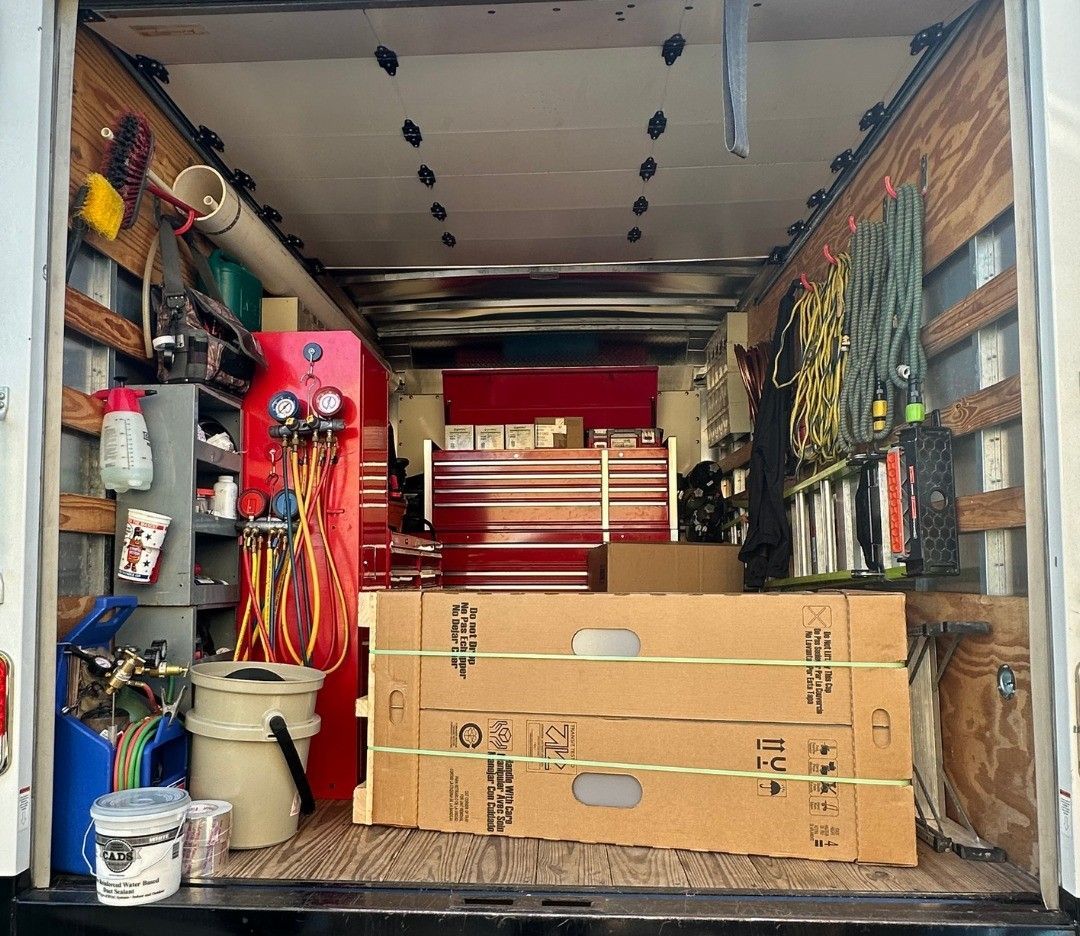 The back of a truck is filled with boxes and tools