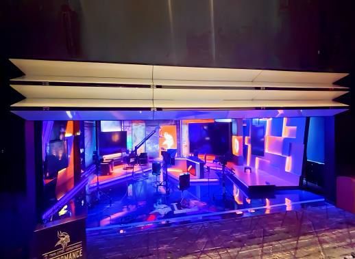 Neon-lit indoor pool with blue water, lounge chairs, and modern lounge area at night