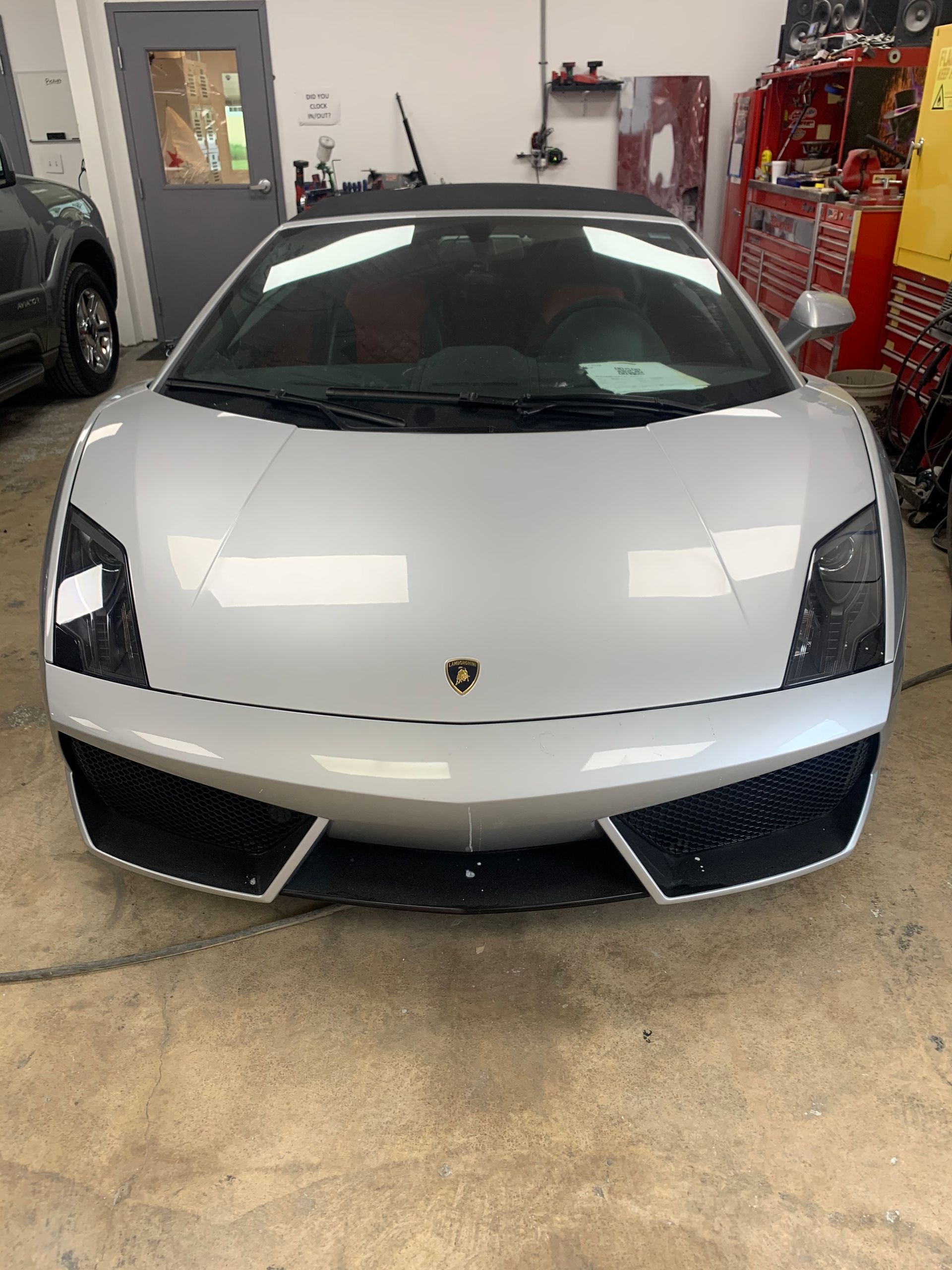 A silver lamborghini gallardo is parked in a garage.