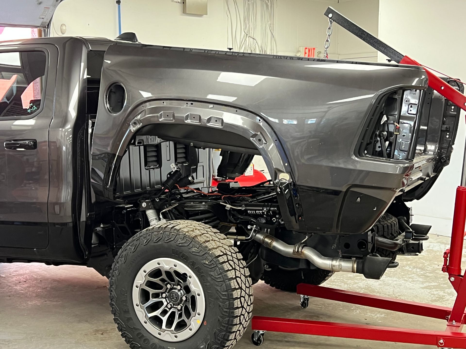 A truck is sitting on top of a red stand in a garage.