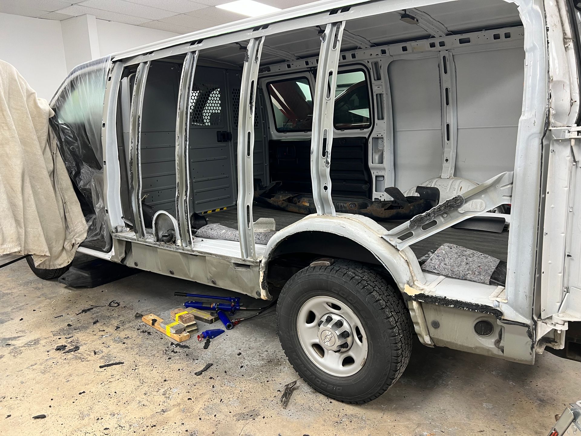 A white van is being remodeled in a garage.