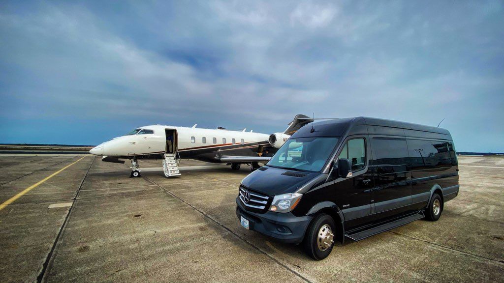 A van is parked next to a private jet on a runway.