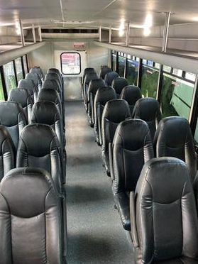 The inside of a bus with rows of seats and a window.