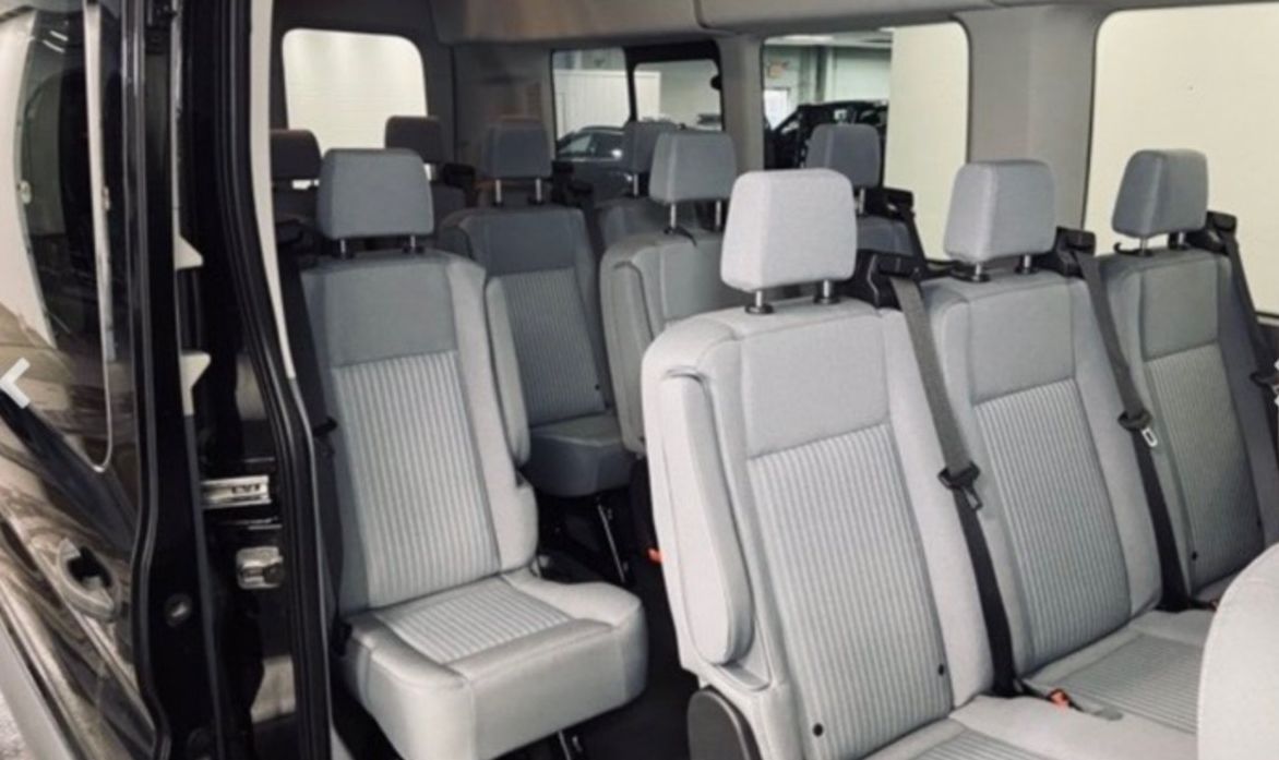 The inside of a van with a lot of seats and a lot of windows.