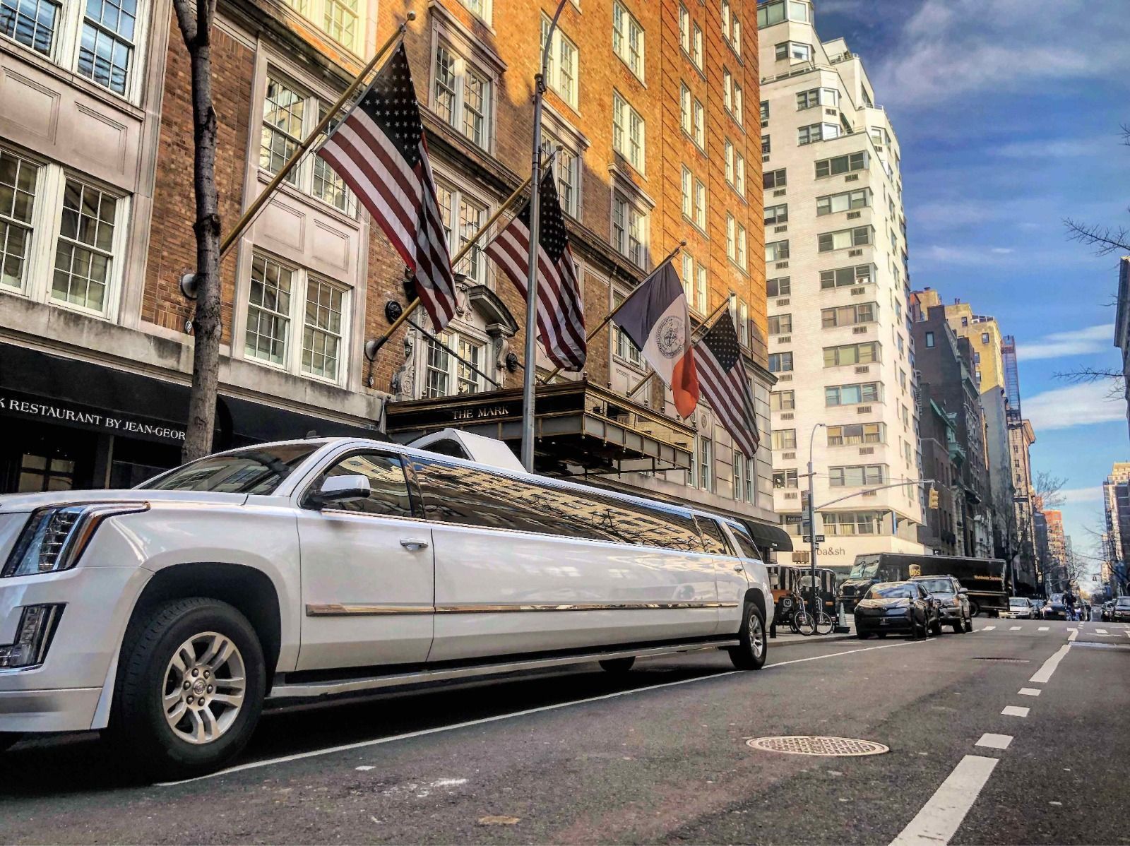 A long white limousine is parked on the side of a city street.