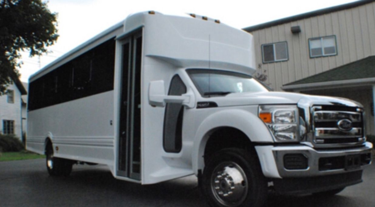 A white ford truck is parked in front of a building.