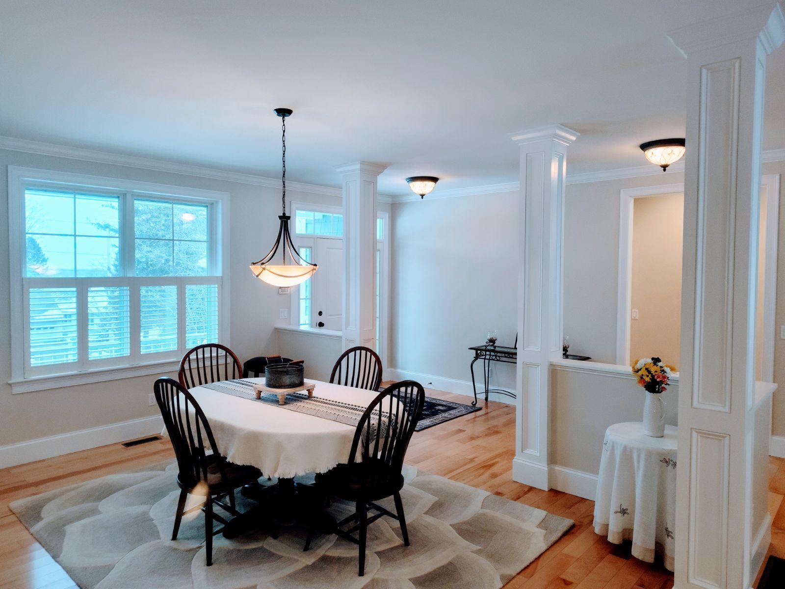 A dining room with a table and chairs and a chandelier hanging from the ceiling